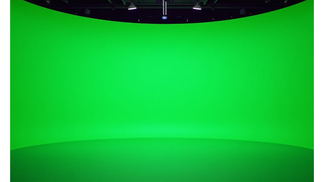 Immense cyclorama fond vert professionnel dans un studio de télévision moderne, éclairé de manière uniforme, prêt pour une incrustation vidéo impeccable et des effets spéciaux avancés. Un moniteur affiche un aperçu de l'incrustation en temps réel.